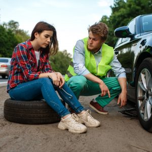 Young couple repair flat tyre, car breakdown